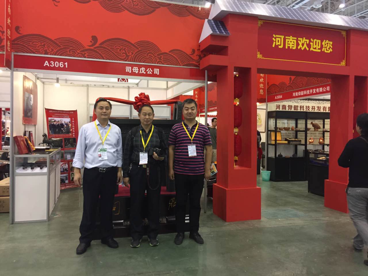 安陽(yáng)市旅游局領(lǐng)導(dǎo)觀看展出的殷商文化展品，并在司母戊鼎前合影
